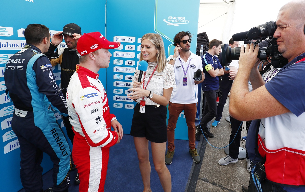 Áttetsző felsőben pózol a Formula E riporternője egy Jaguar motorháztetőjén